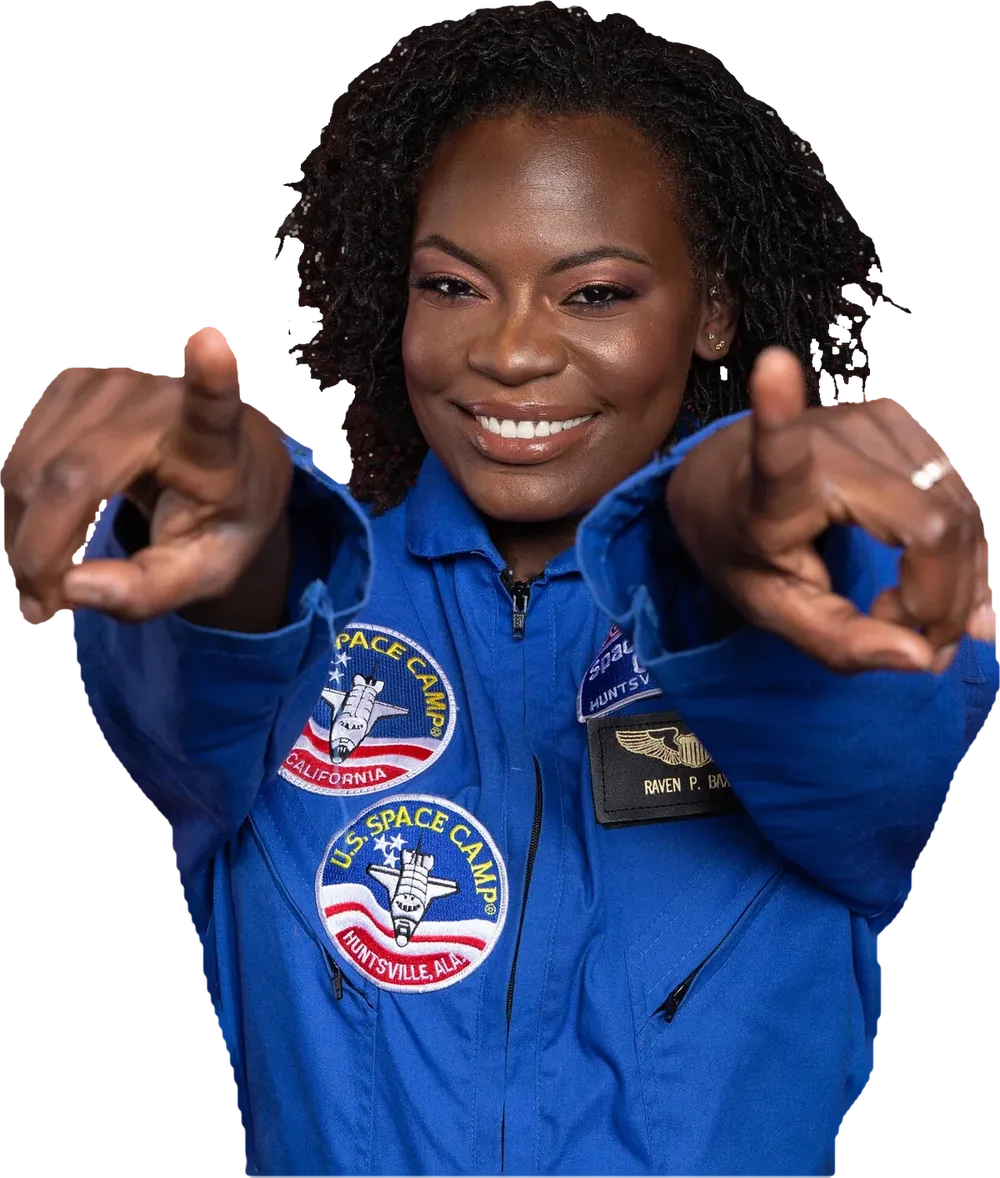 Dr. Raven Baxter in a blue Space Camp flight suit, smiling and pointing at the viewer