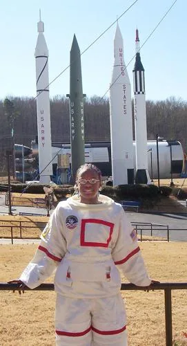 Raven as a kid in a spacesuit at the Space Camp rocket park