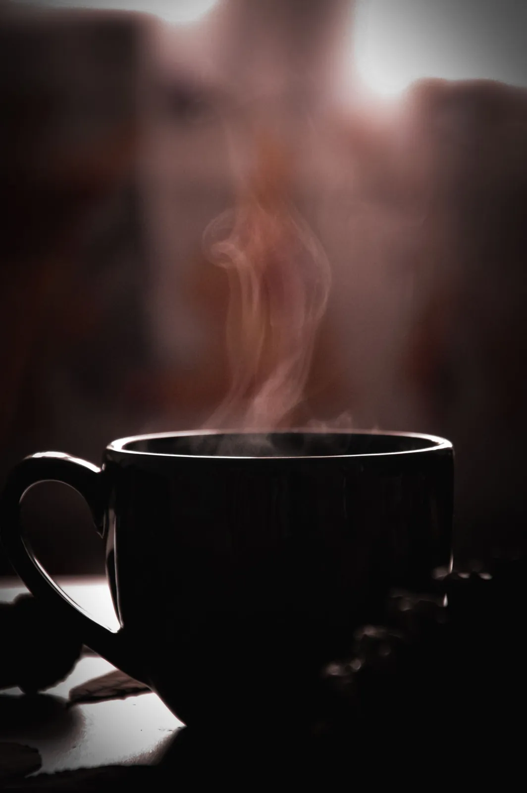 A steaming cup of coffee on a table indoors