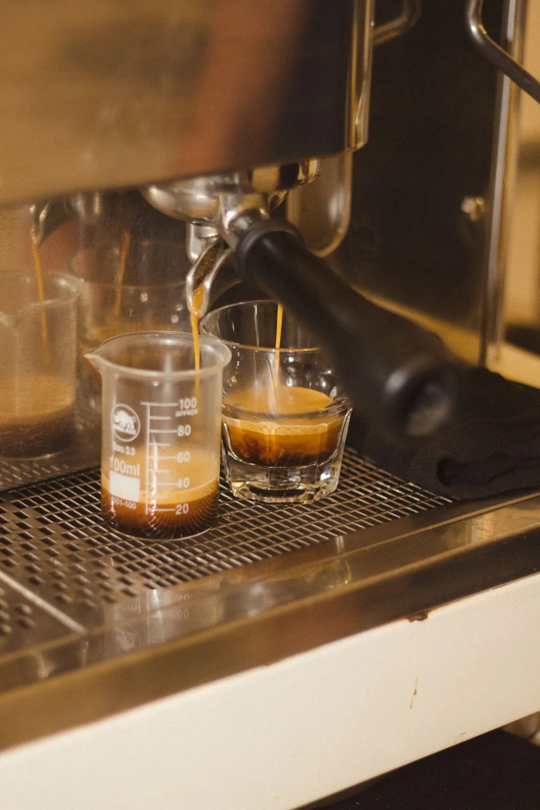 Espresso brewing from a coffee machine into a small glass