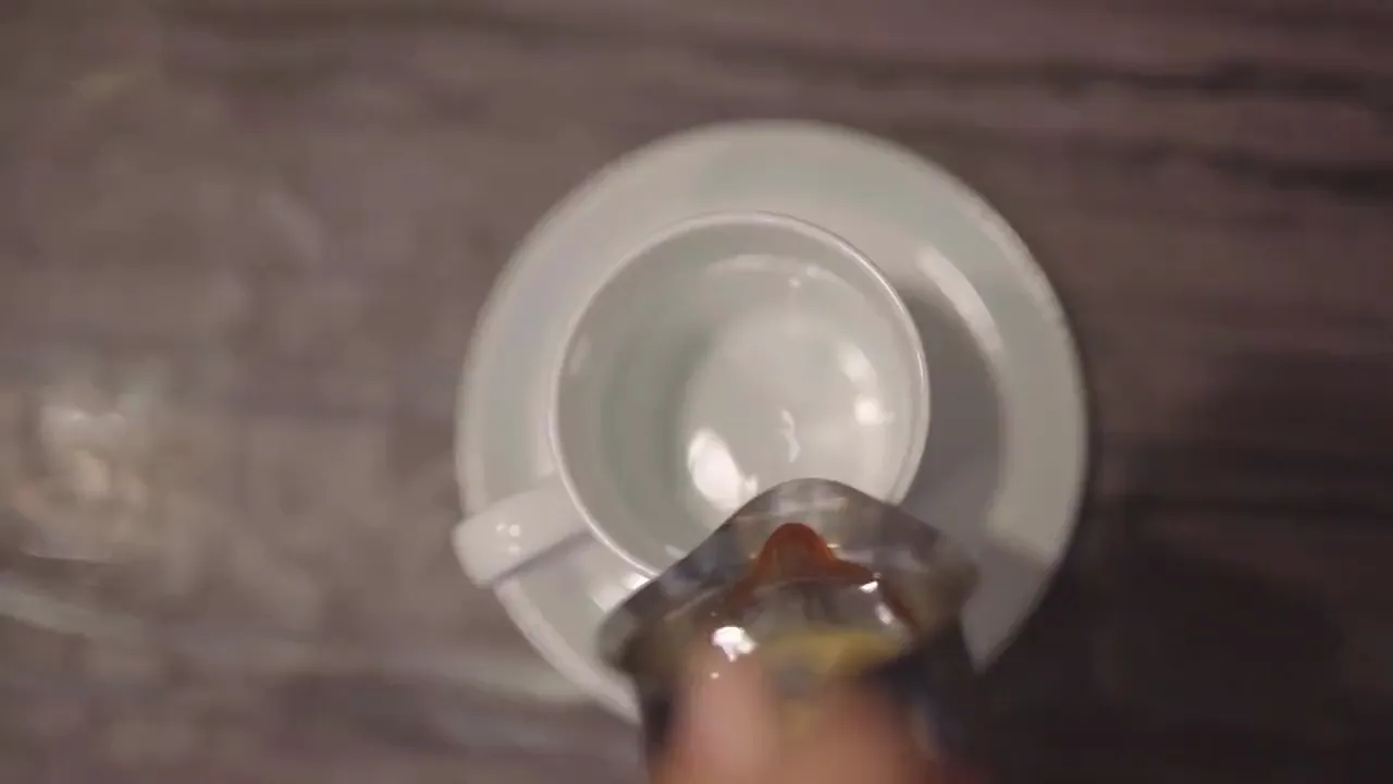 Hot coffee being poured into a mug, seen from above