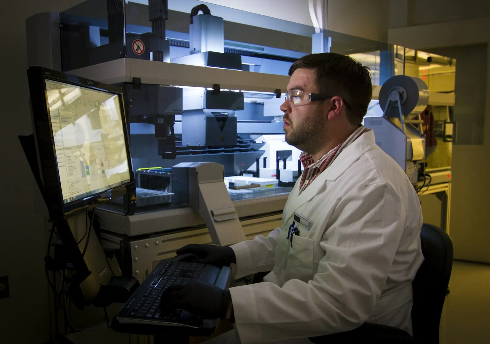 A lab technician reviewing DNA sequencing data on a computer