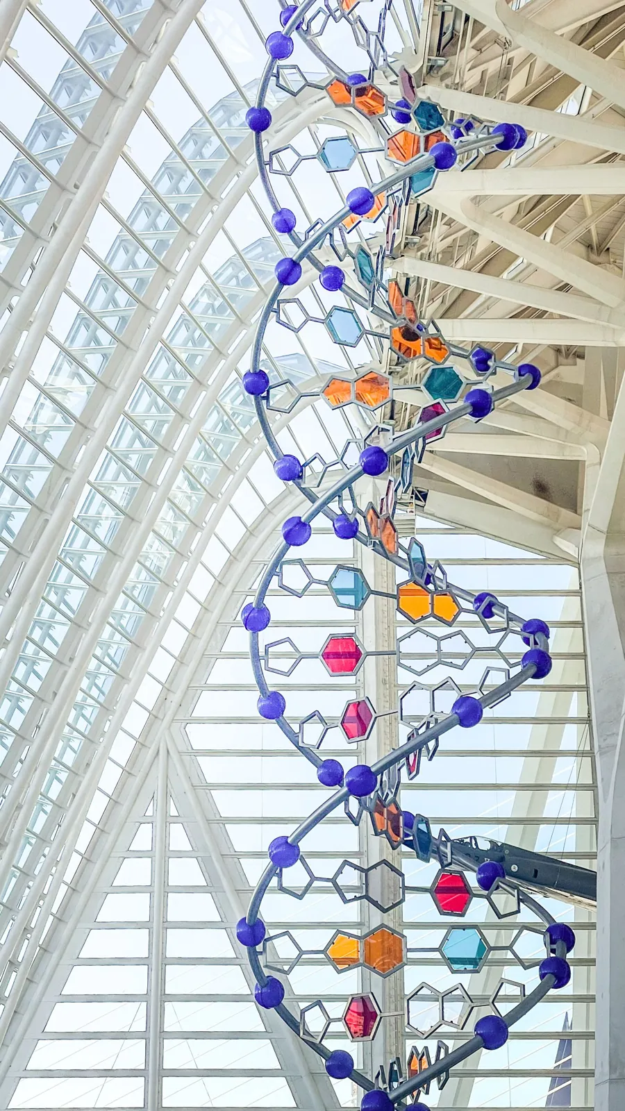 A tall, colorful sculpture of a DNA double helix inside a science museum in Valencia, Spain