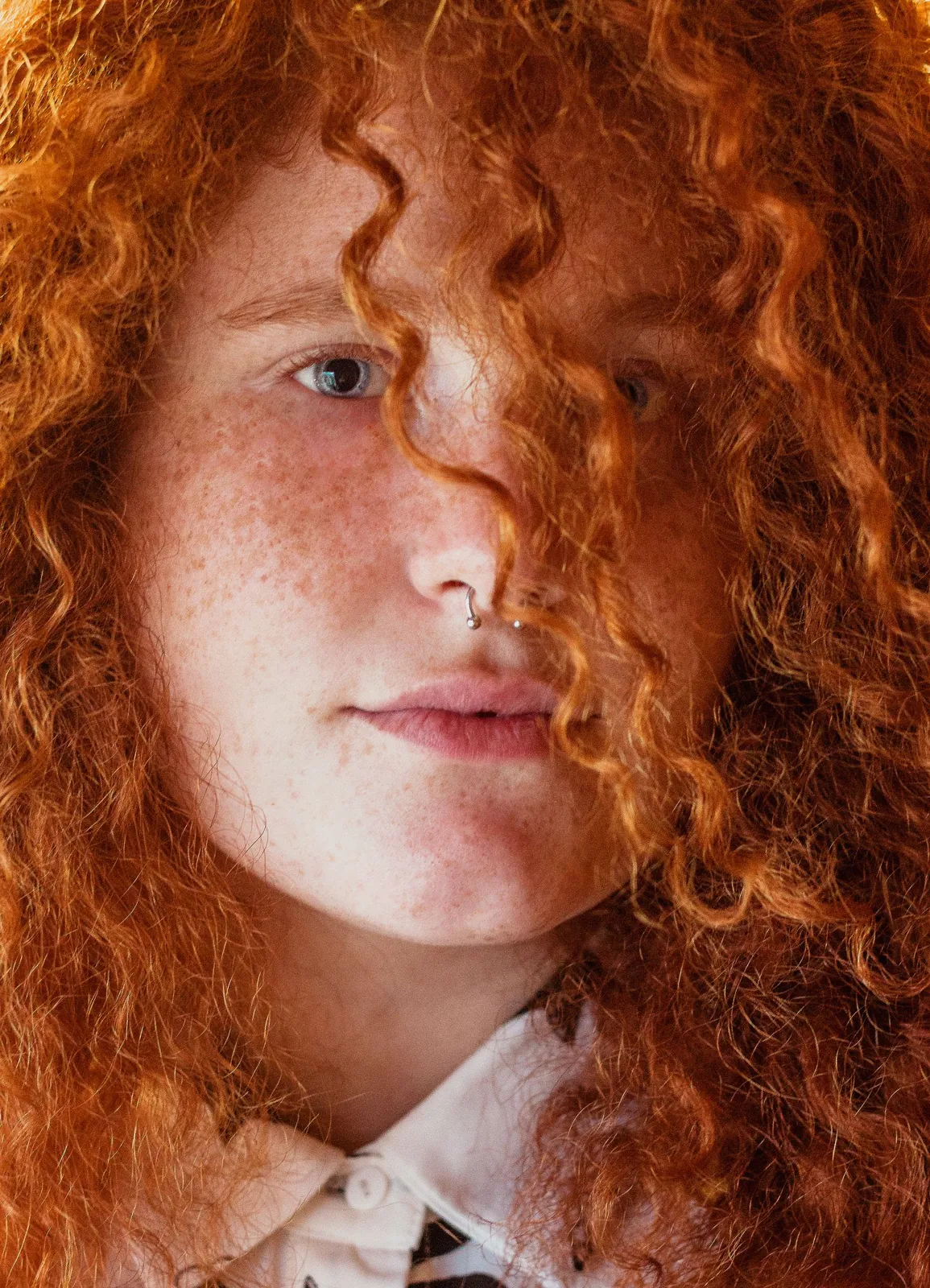 A woman with bright red curly hair and freckles