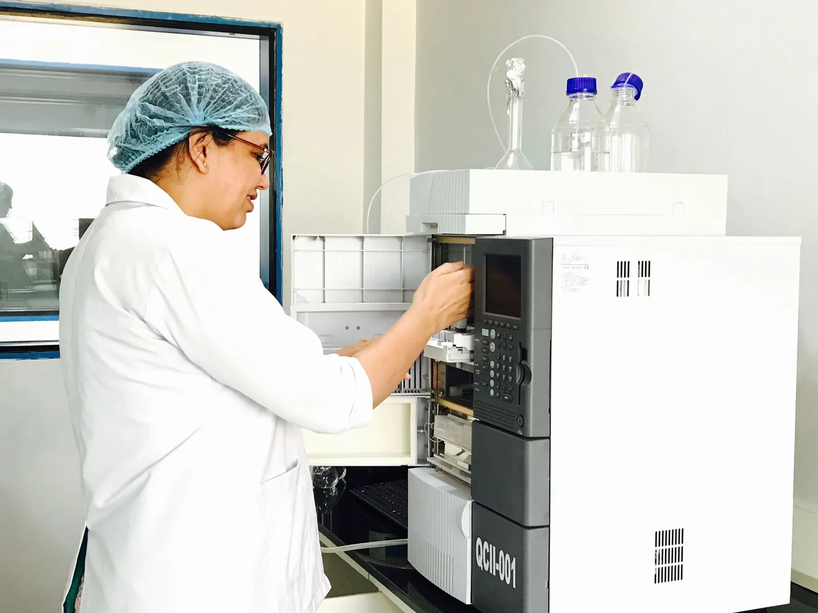 A woman scientist using a chemistry instrument in a lab