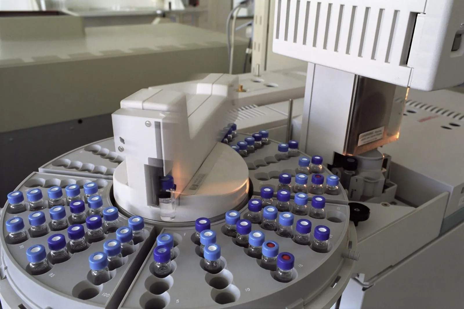 Rows of sample vials loaded into a chromatograph, a lab machine that separates and measures molecules