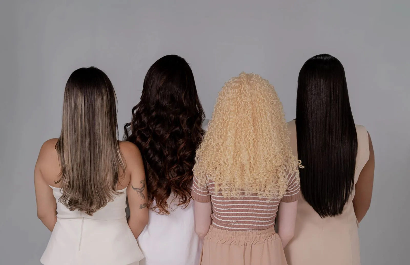 Four women seen from behind with different hair colors and textures