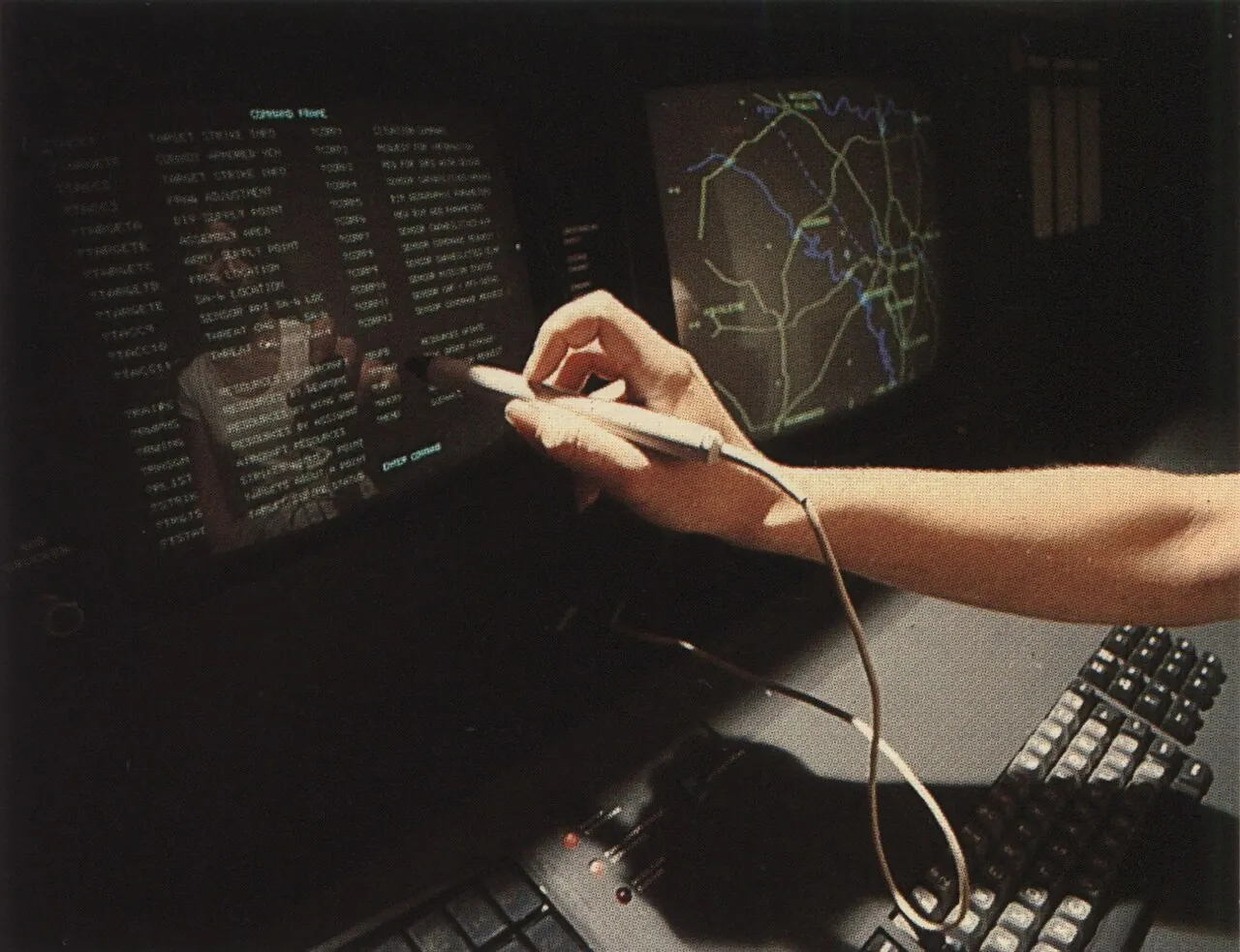 A woman uses a light pen to pick items on the screen of an IBM computer terminal