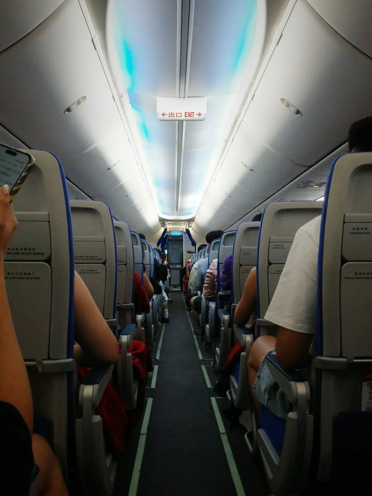 Passengers in rows of seats along the aisle of an airplane cabin