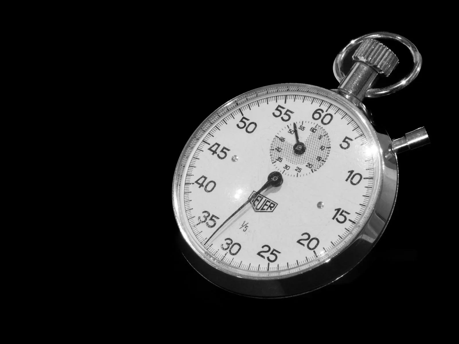Close-up of a silver stopwatch on a black background