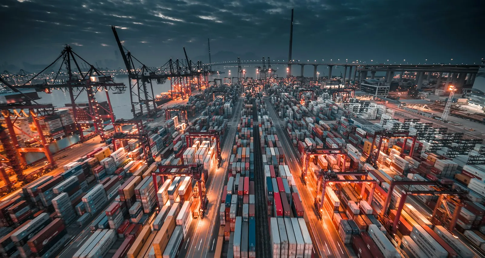 Stacks of cargo containers and cranes at a busy shipping port in Hong Kong