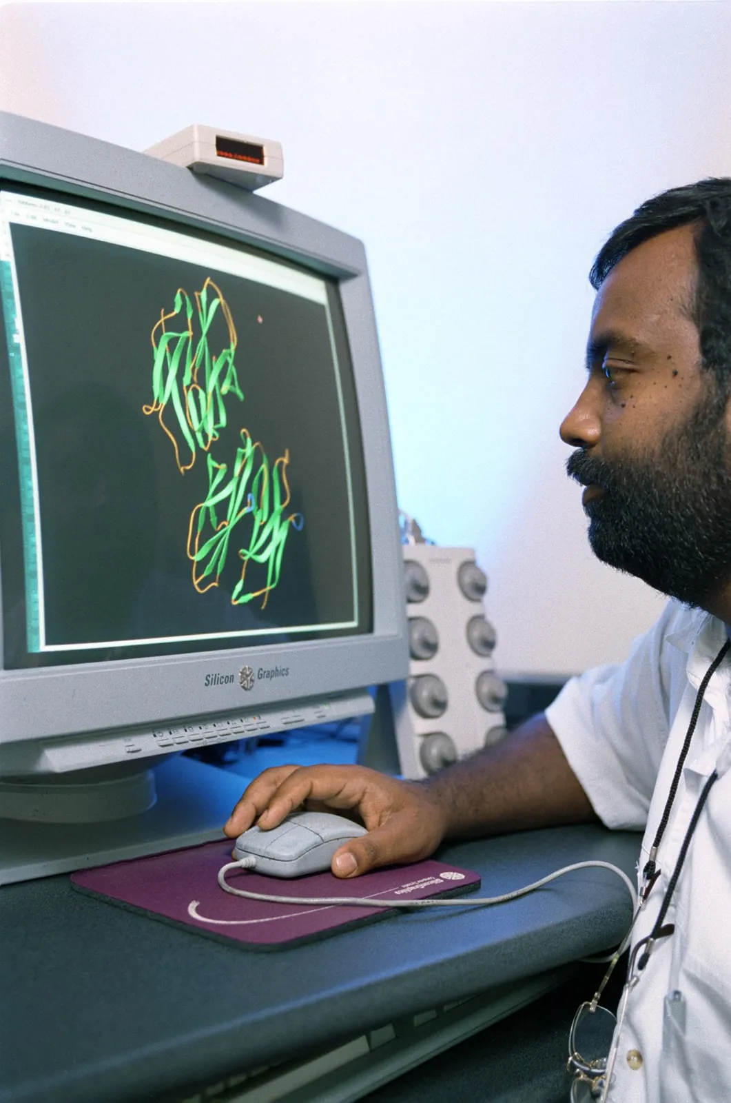 A researcher studies a 3D model of the insulin protein on a computer screen